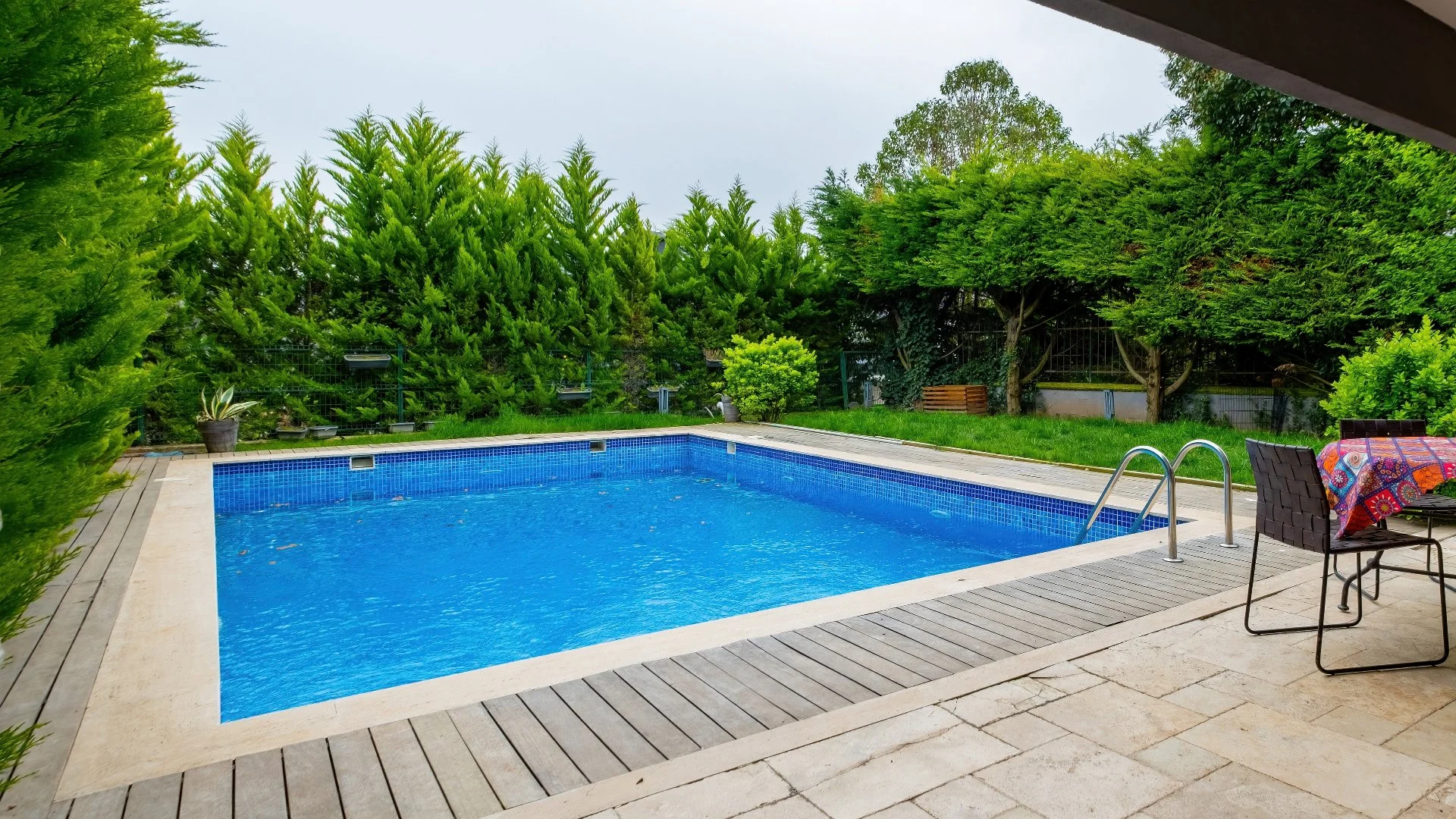 Swimming pool surrounding by an outdoor living space.