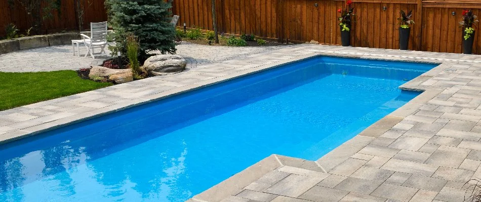 Fiberglass pool in %%targetarea1-ks%%, %%state-ks%%, beside a green lawn and a patio.