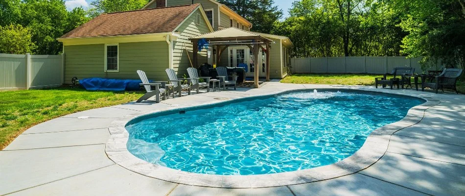 Home with concrete patio and pool in Athens, AL.