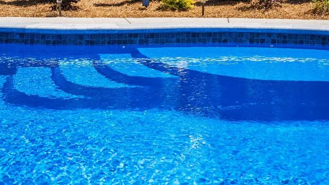 Fiberglass pool with landscaping at a home in Huntsville, AL.