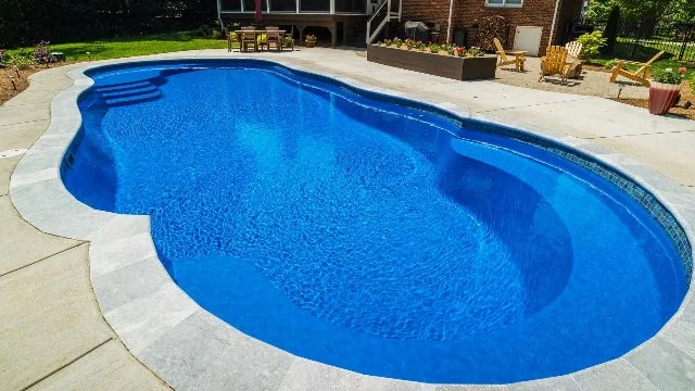 Fiberglass swimming pool and outdoor living space at a home in Huntsville, AL.