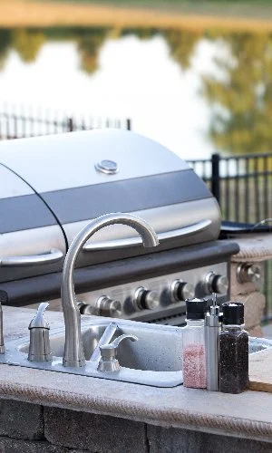 Outdoor kitchen with a grill in sink.